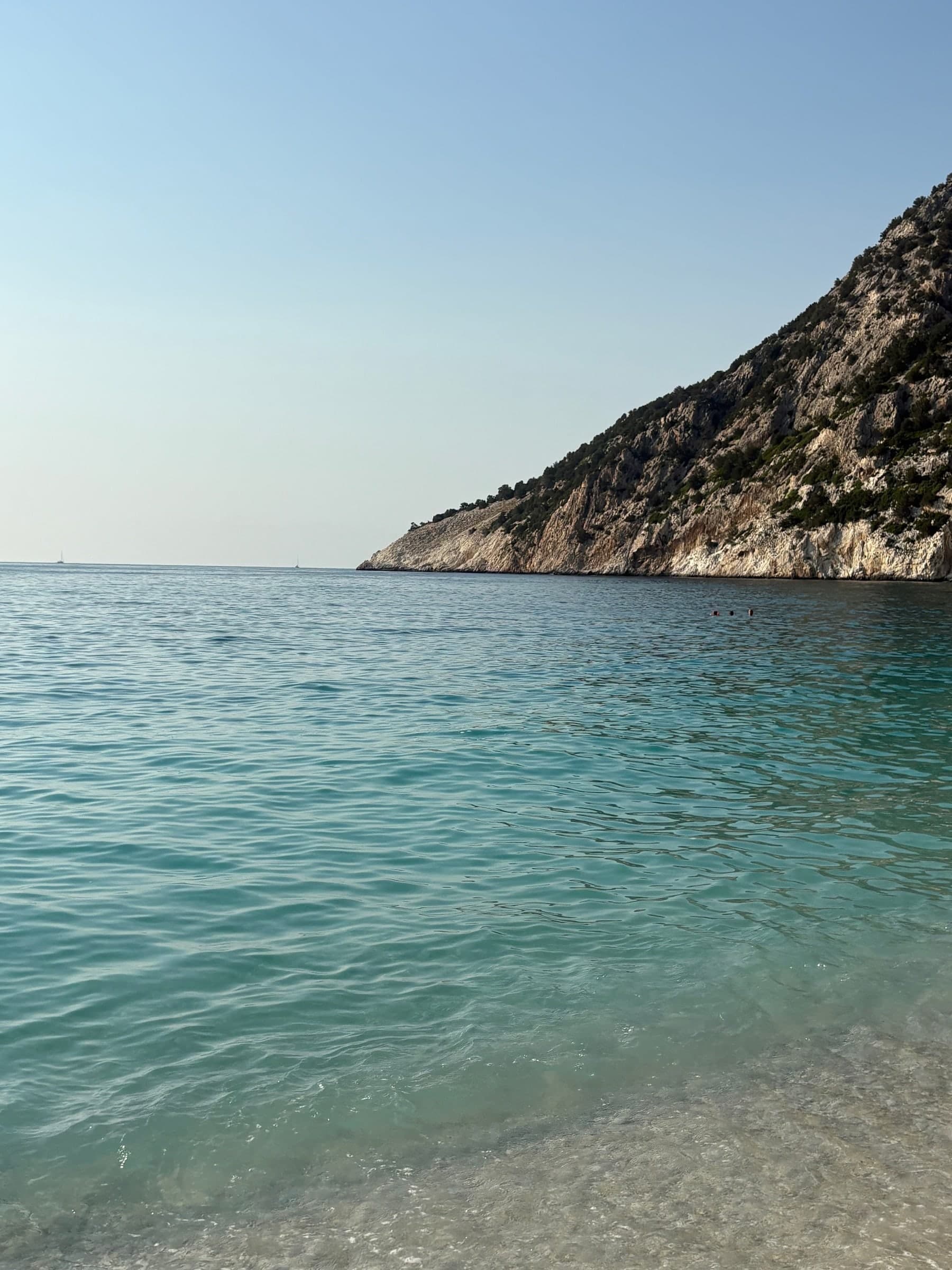 Clear turquoise sea against a rocky headland