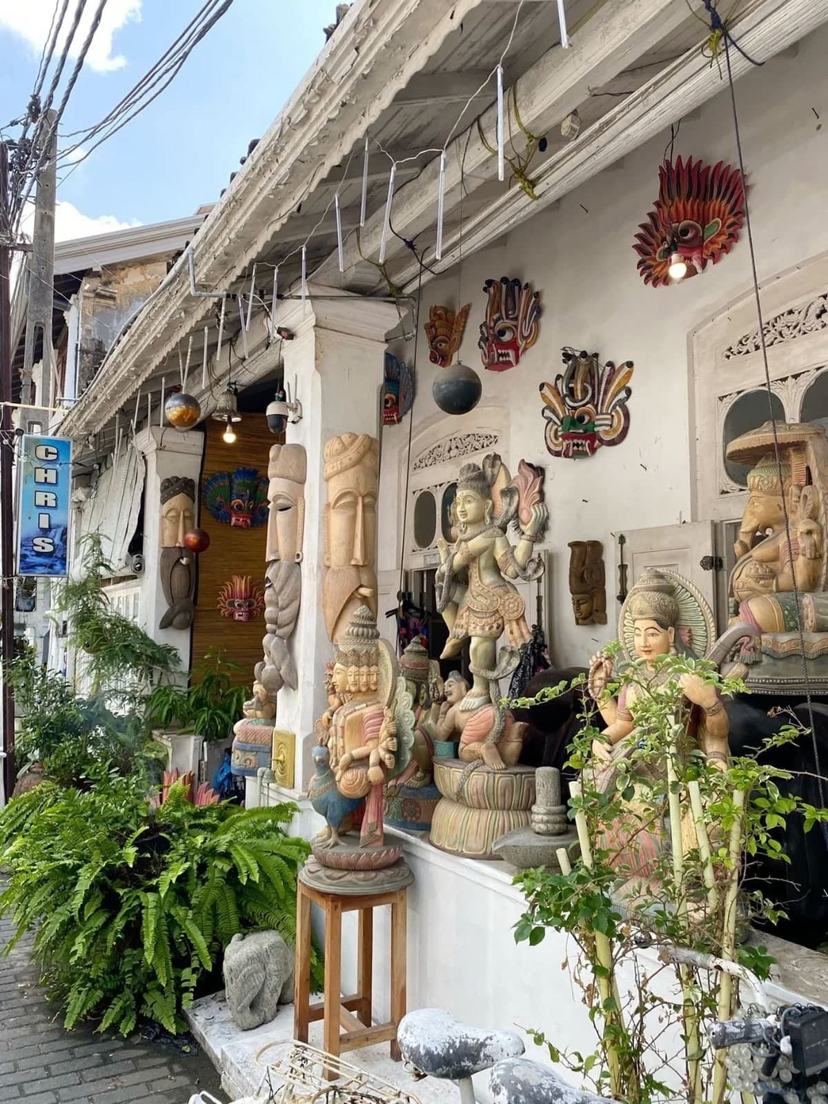 A shop front covered in carved wooden masks and statues